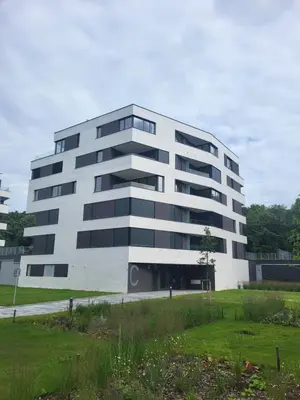 a large white building with a field in front of it at New apartment in Karlín, Praha 8, close to center in Prague