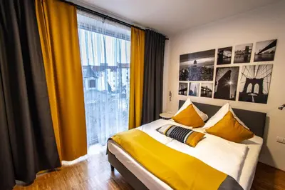 a bedroom with a bed with yellow curtains and a large window at Modern Apartment With Balcony and Garage in Prague
