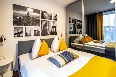 a bedroom with two beds with yellow and blue pillows at Modern Apartment With Balcony and Garage in Prague