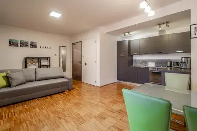 a living room with a couch and a kitchen at Modern Apartment With Balcony and Garage in Prague