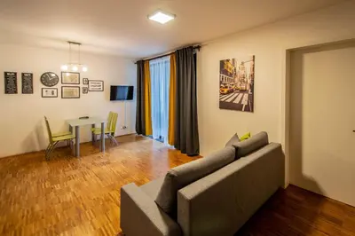 a living room with a couch and a table at Modern Apartment With Balcony and Garage in Prague