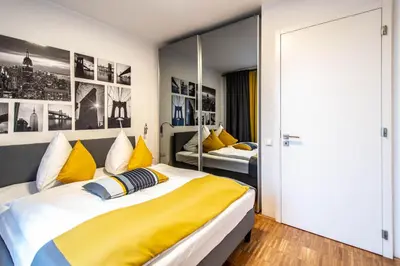 a bedroom with two beds with yellow and blue pillows at Modern Apartment With Balcony and Garage in Prague