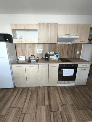 a kitchen with wooden cabinets and a sink and a refrigerator at Kralovak in Králŭv Dvŭr