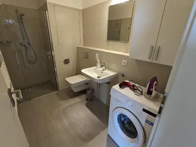 a bathroom with a washing machine and a sink at Cozy Apartment with Big Terrace in Central Prague - Karlín in Prague