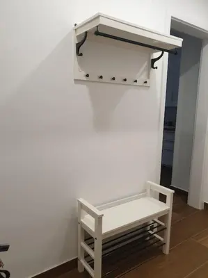 a white wall with a bench in a room at Prague Downtown Vinohrady - next to Havlícek Park in Prague