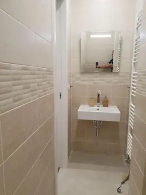 a bathroom with a sink and a man taking a picture in the mirror at Prague Downtown Vinohrady - next to Havlícek Park in Prague