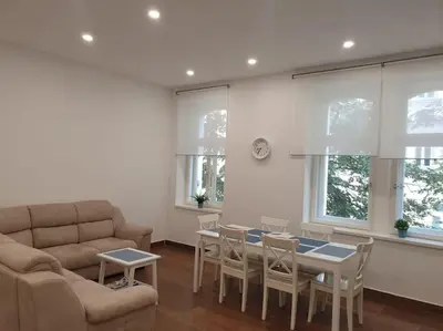 a living room with a couch and a table and chairs at Prague Downtown Vinohrady - next to Havlícek Park in Prague