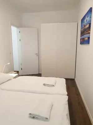 two white beds in a room with a mirror at Prague Downtown Vinohrady - next to Havlícek Park in Prague