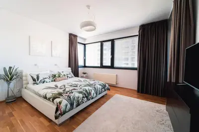 a bedroom with a bed and some windows at Prague Marina River View Apartment Close To City Centre FREE PARKING in Prague