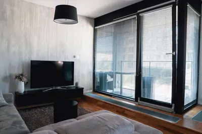 a living room with a couch and a large window at Prague Marina River View Apartment Close To City Centre FREE PARKING in Prague