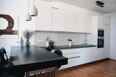 a kitchen with a black table and white cabinets at Prague Marina River View Apartment Close To City Centre FREE PARKING in Prague