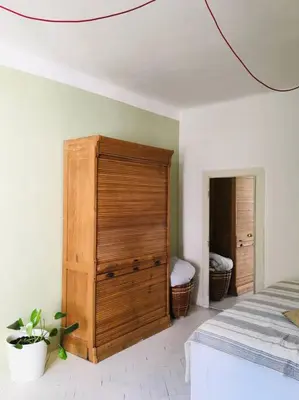 a bedroom with a large wooden dresser next to a bed at Byt v srdci Žižkova Praha 3 in Prague