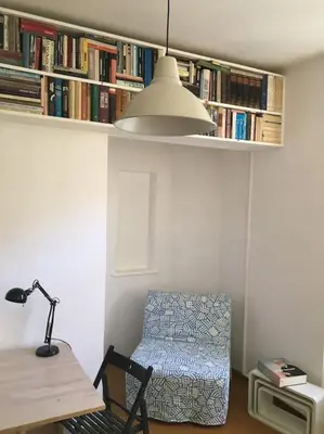a room with a chair and a desk and a book shelf at Byt v srdci Žižkova Praha 3 in Prague