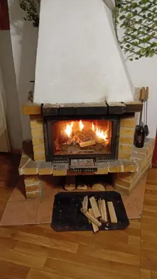 a brick fireplace with snow on top of it at Rekreační chata Kocába in Štěchovice