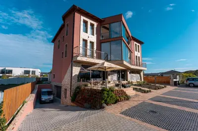 a brick building with an umbrella on a street at LASKARA Garden Apartment by Prague Forest in Nové Jirny