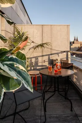 a patio with two tables and chairs on a balcony at TurnKey I Central Apartment with Terrace in Prague