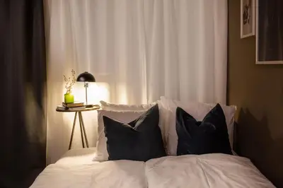 a bed with four pillows and a table with a lamp at TurnKey I Central Apartment with Terrace in Prague