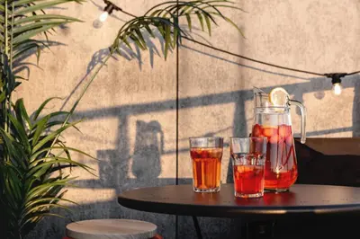 a table with two glasses and a pitcher of juice at TurnKey I Central Apartment with Terrace in Prague