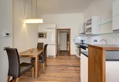 a kitchen and dining room with a wooden table and chairs at Historic Centre Apartments II in Prague