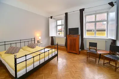 a bedroom with a bed and a tv and a table at Historic Centre Apartments IV in Prague