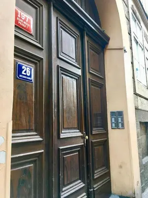 a large wooden door on a building with a sign on it at Historic Centre Apartments IV in Prague