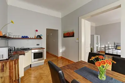 a kitchen and dining room with a table with a vase of flowers at Historic Centre Apartments IV in Prague