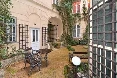 a patio with a table and chairs next to a building at Historic Centre Apartments IV in Prague