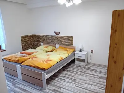 a bedroom with a large bed with yellow sheets at Apartmány Kateřina in Ricany