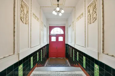 a red door in a hallway with green tiles at Kubelíkova 32 Residence in Prague
