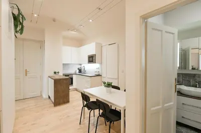a kitchen with white cabinets and a table and chairs at Kubelíkova 32 Residence in Prague