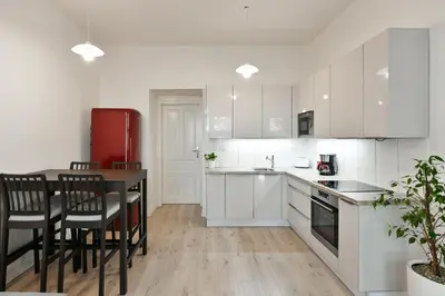 a kitchen with white cabinets and a red refrigerator at Kubelíkova 32 Residence in Prague