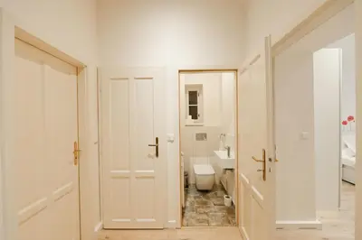 a white bathroom with a toilet and a sink at Kubelíkova 32 Residence in Prague