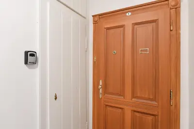 a wooden door is next to a white wall at Kubelíkova 32 Residence in Prague