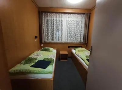 a small room with two beds and a window at Hotel a ubytovna Zimní stadion Slaný in Slaný