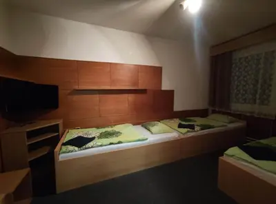 a bedroom with two beds and a tv in it at Hotel a ubytovna Zimní stadion Slaný in Slaný
