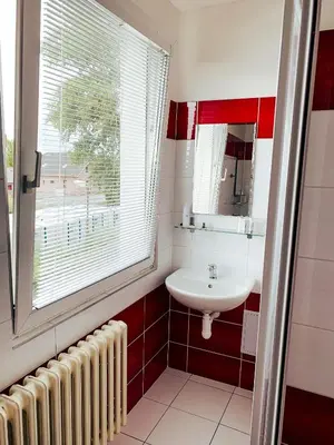 a bathroom with a white sink and a window at Hotel a ubytovna Zimní stadion Slaný in Slaný