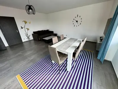a dining room table with chairs and a clock on the wall at Byt apartman 74m2 vyhled klid priroda in Prague