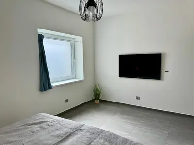 a bedroom with a bed and a flat screen tv at Byt apartman 74m2 vyhled klid priroda in Prague