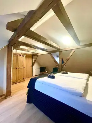 a large bed in a room with wooden ceilings at U Zeleného jalovce in Prague