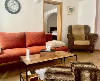 a living room with a red couch and a chair at U Zeleného jalovce in Prague