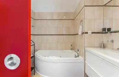 a bathroom with a white tub and a sink at Lenka's cozy Red studio + Lenka's cozy Gold apartment in Prague
