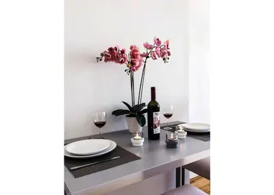 a table with a bottle of wine and a vase of flowers at Modern Apartment Riegrovy sady in Prague