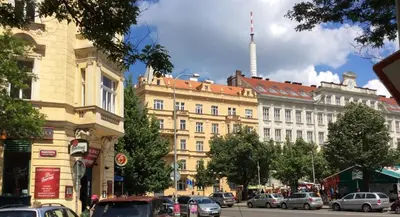 a city street with cars parked in front of a building at Modern Apartment Riegrovy sady in Prague