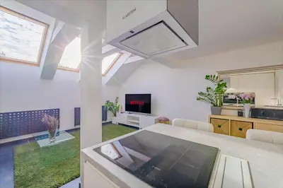 a large kitchen and living room with a large window at ModaLoft Duplex by Rentez in Prague