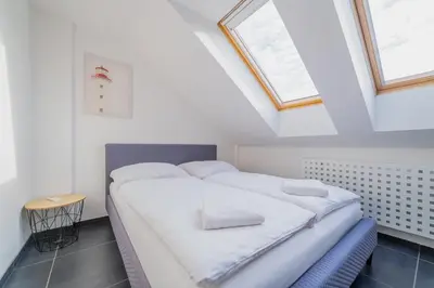 a bedroom with two beds in a room with skylights at ModaLoft Duplex by Rentez in Prague
