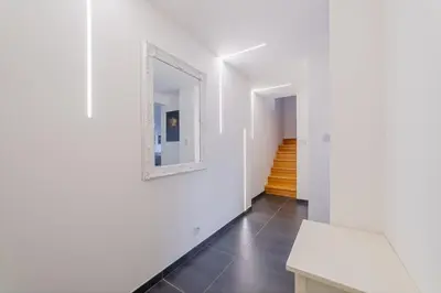 a hallway with white walls and a mirror on a wall at ModaLoft Duplex by Rentez in Prague
