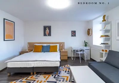 a bedroom with a bed and a couch and a table at The Bookhouse, 5-bedroom residence by Prague Castle in Prague
