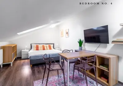 a bedroom with a bed and a table and chairs at The Bookhouse, 5-bedroom residence by Prague Castle in Prague