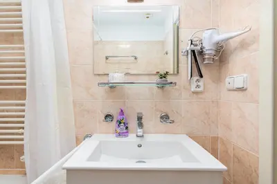 a bathroom with a white sink and a mirror at Private Retreat Close to Stations in Praha 3 in Prague