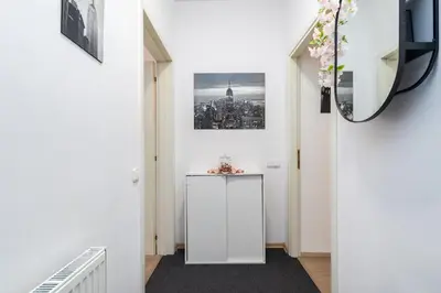 a hallway with a white cabinet and a picture on the wall at Private Retreat Close to Stations in Praha 3 in Prague